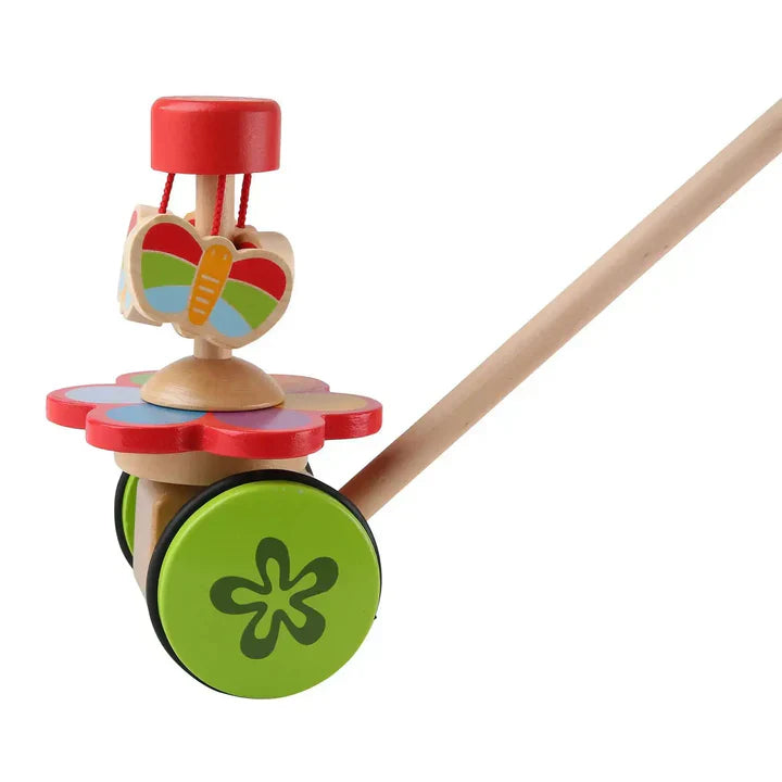 Colorful Hape wooden toys for one-year-olds arranged on a white surface, including a push walker, rhythm instruments, play food set, and block train, at Cuddles and Carriages in Evans, Georgia.