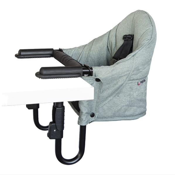 Guzzie+Guss Perch hook-on high chair in Forrest Green clipped to a wooden dining table, with a baby seated at eye level with the family, photographed in a warm fall home setting.