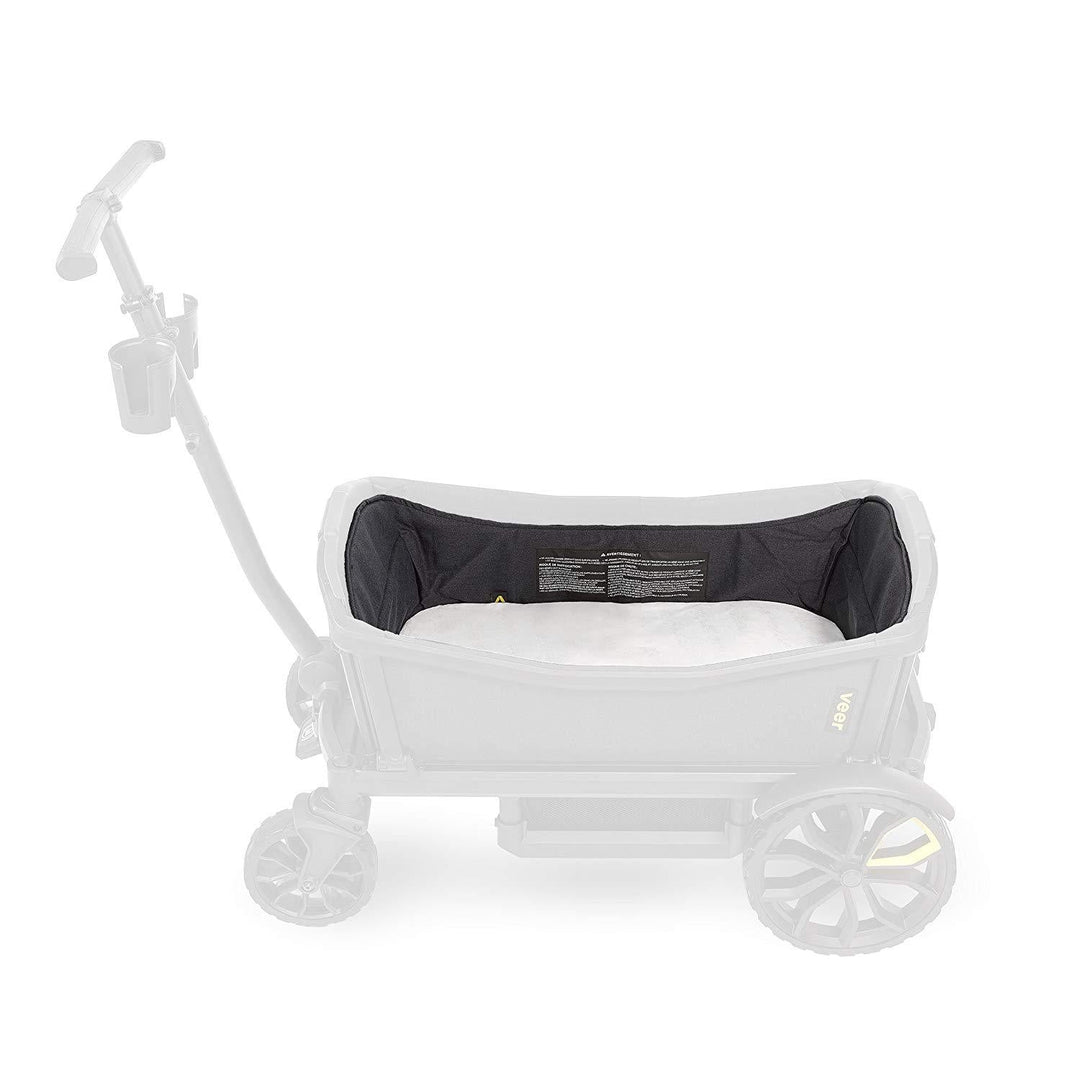 Veer Cruiser stroller-wagon with Nap System bassinet set up outdoors on a fall afternoon, surrounded by autumn leaves, ready for a newborn's first outdoor adventure.