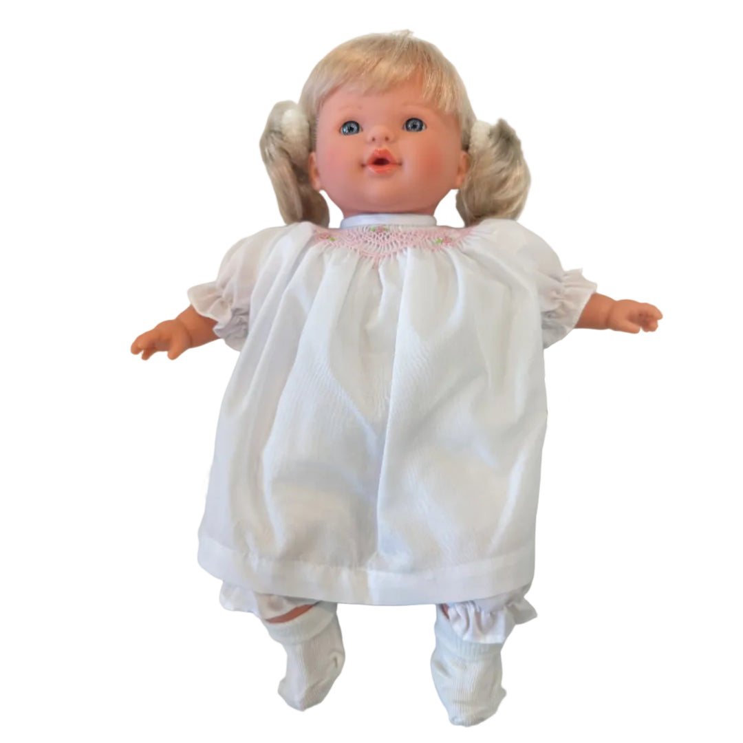 Doll wearing a white outfit with lace details on a light background