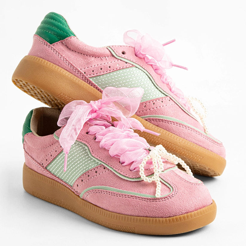 Pair of pink sneakers with green accents on a white background